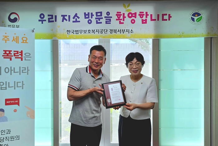 김사연(오른쪽)한국법무보호복지공단 경북서부지소장이 유대연 대표에게 홍보대사 위촉장을 전달하고 있다.<한국법무보호복지공단 경북서부지소 제공>