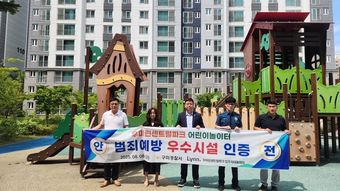 구미경찰서 직원과 산동읍 우미린 센트럴파크 입주민들이 아파트 내 놀이터 '범죄예방 우수시설' 인증 현수막을 들고 있다.<구미경찰서 제공>