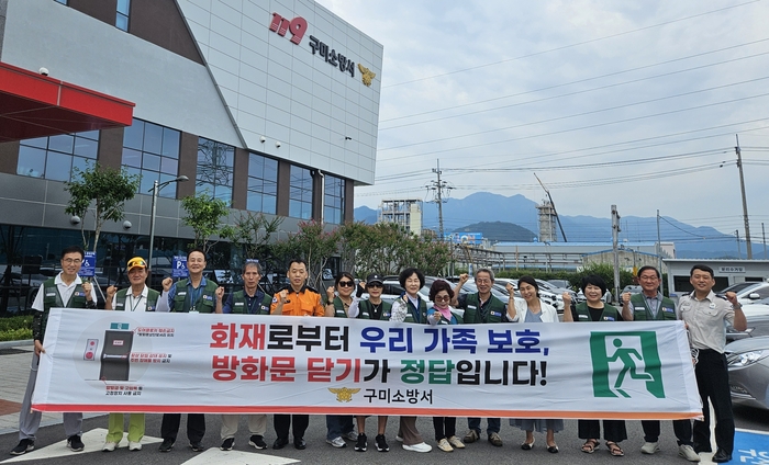 구미소방서 직원들과 대한노인회 구미시지회 시니어 소방안전지원팀이 방화문 닫기 합동 캠페인을 펼친 후 소방서 앞에서 단체사진 촬영을 하고 있다. <구미소방서 제공>