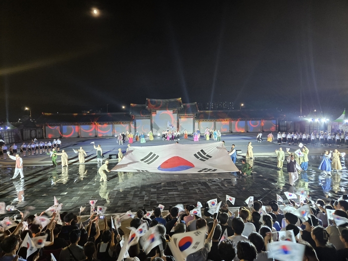 지난해 8월 경북 안동 탈춤공원 특설무대에서 '왕의나라 시즌3-나는 독립군이다' 공연이 펼쳐지고 있는 가운데, 관객들이 태극기를 흔들며 환호하고 있다. <극단 맥 제공>