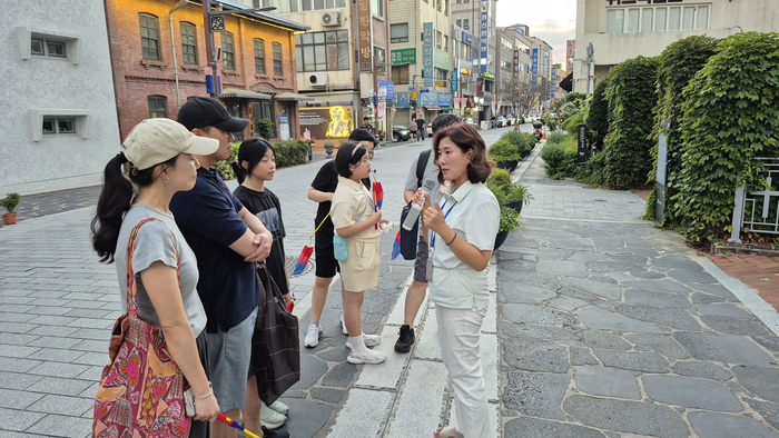 16일 오후 대구 중구청이 운영하는 '근대골목 밤마실 투어' 참가자들이 대구읍성에 대한 설명을 듣고 있다. 발밑 밝은 회색 돌길이 당시 성벽이 지나갔던 흔적을 표시한 구간이다. 조윤화 기자
