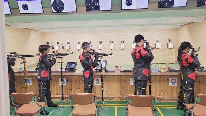 최호건(왼쪽 두 번째)군이 동원중 실내사격장에서 공기소총을 겨누고 집중하고 있다.