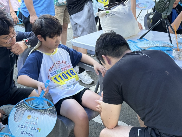 지난 23일 열린 '제16회 팔공산 달빛 걷기 대회'에 자원봉사자로 참여한 우리들병원 물리치료사들이 참가자들에게 무료 테이핑 봉사를 하고 있다. 구경모기자