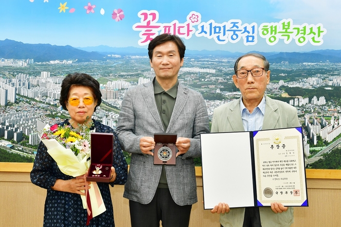 조현일 경산시장이 국방부 장관을 대신해 고 장해익 상병 유가족에게 화랑무공훈장을 전수하고 있다. <경산시 제공>