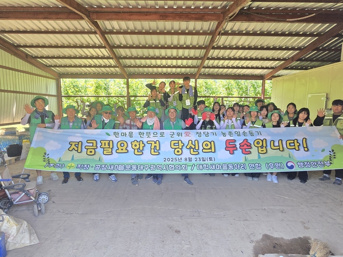 직장·공장새마을운동대구시협의회와 대구시대학새마을동아리연합회 회원들이 23일 군위군에서 열린 '한 마음 한 뜻으로 군위愛 정담기 농촌일손돕기' 행사에 참여해 기념촬영을 하고 있다.<대구시새마을회 제공>