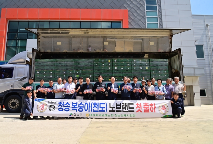 27일 대경사과원예농협 청송경제사업장에서 전국 노브랜드 매장에 '청송 천도복숭아' 첫 출하를 기념하는 사진을 촬영하고 있다.<청송군 제공>