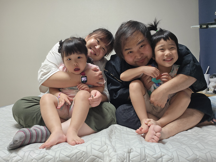 김용기 씨(오른쪽)와 아내 하라다 유키코 씨(왼쪽)의 자녀 김주안 군(7)과 김주아 양(6)이 부모 품에 안겨 활짝 웃고 있다. 김용기·하라다 유키코 부부 제공