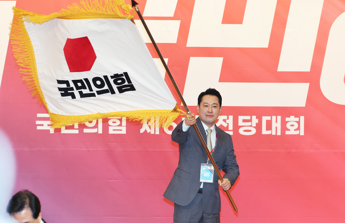 국민의힘 장동혁 신임 당 대표가 26일 서울 여의도 국회도서관에서 열린 제6차 전당대회 결선에서 당 대표로 선출된 뒤 당기를 흔들고 있다. 연합뉴스