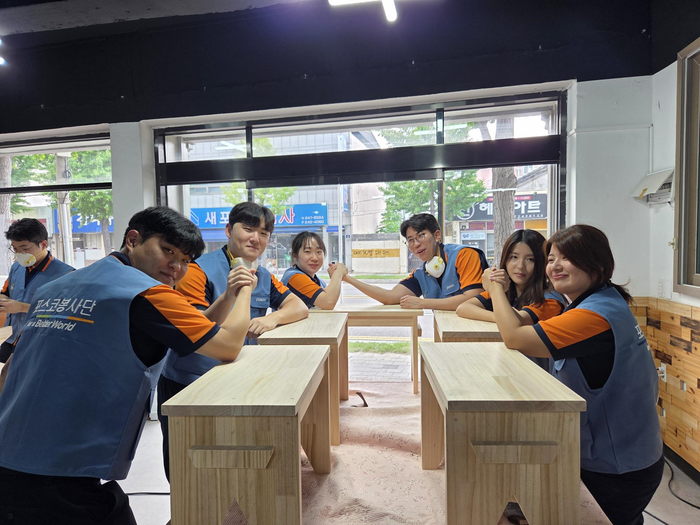 지난 달 22일 포스코 신입사원들이 지역 사회에 기부할 원목 벤치를 제작한 뒤 기념촬영을 하고 있다.<포스코 제공>