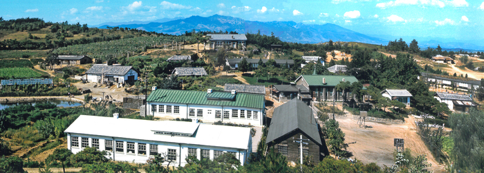 경산 신천동의 메노나이트 실업학교 전경. 1964년 촬영된 사진을 복원해 한눈에 볼 수 있게 했다. 흰색 지붕과 바로 뒤 초록색 지붕의 건물은 각각 교실과 교무실로 지금까지 남아있다. <메노나이트 아카이브 제공>