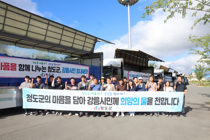 청도군이 극심한 가뭄을 겪고 있는 강릉시에 가뭄 극복을 위한 생수 지원 사업을 실시한 후 단체사진을 찍고 있다. <청도군 제공>