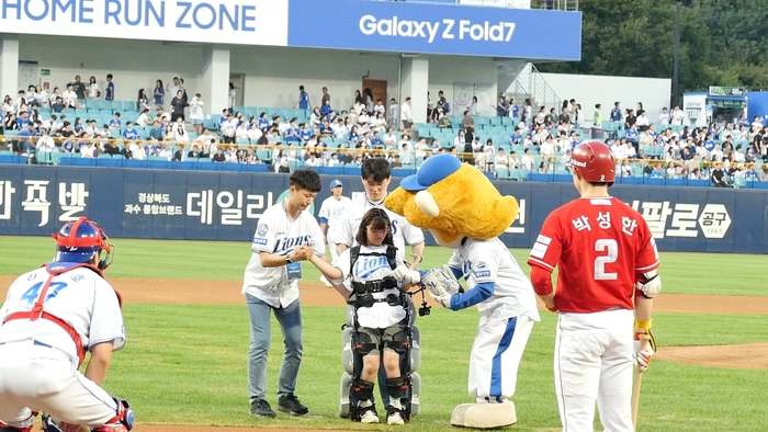 대구성보학교 김예원 학생(고교 2년)이 지난 11일  대구 삼성라이온즈파크에서 시구를 하기 위해 관계자의 도움을 받고 있다. <대구시교육청 제공>