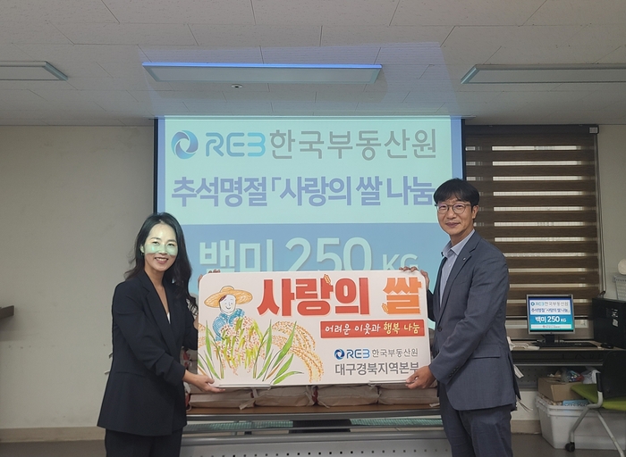 한국부동산원 대구경북지역본부 장우석 본부장(오른쪽)과 동구재가노인돌봄센터 최남출센터장(왼쪽)이 추석맞이 사랑의 쌀 나눔 행사 사진을 촬영하고 있다. <한국부동산원 제공>