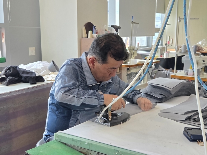 제봉뜰 두류봉제지식산업센터에 입주한 업체의 근로자가 다리미로 원단을 다리고 있다. 이승엽 기자