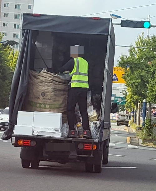 대구 동구의 한 도로에서 운행 중인 쓰레기수거차 뒷칸에 환경미화원이 서 있다. 강명주 시민기자 kmejuw7@hanmail.net