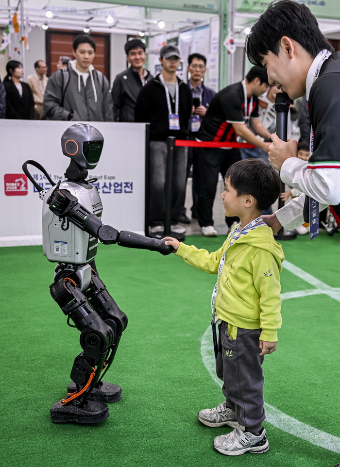 22일 대구 엑스코에서 열린 미래혁신기술박람회(FIX 2025) 내 탑로보틱스 부스에서 휴머노이드 로봇이 어린이와 축구를 한 후 악수를 하고 있다. FIX 2025는 미래형 모빌리티와 로봇 산업의 융합을 주제로 25일까지 엑스코 전관에서 진행된다.
이현덕기자 lhd@yeongnam.com