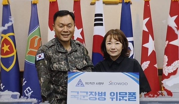 손민희 <주> 서우 대표가 최근 제2작전사령부에 이불 300채를 전달한 후 김호복 제2작전사령관과 함께 기념사진을 찍고 있다. <서우 제공>