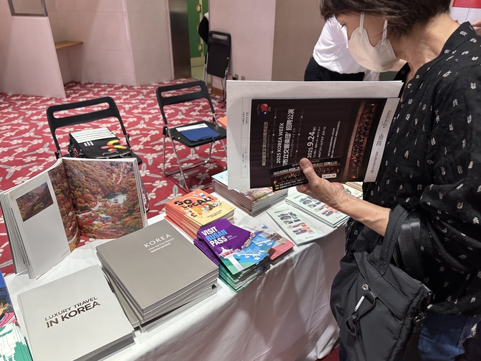 지난달 24일 일본 히로시마 JMS애스터플라자 대공연장 로비에 마련된 한국관광공사 부스에서 한 관람객이 홍보 책자를 둘러보고 있다. <사진=정수민기자>