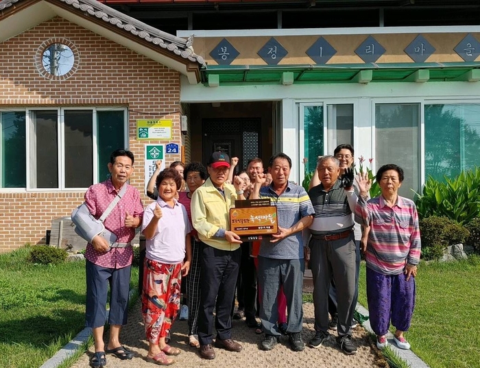 성주군 초전면 봉정1리 주민들이 소각산불 없는 녹색우수마을로 선정돼 기념사진을 촬영하고 있다. <성주군 제공>