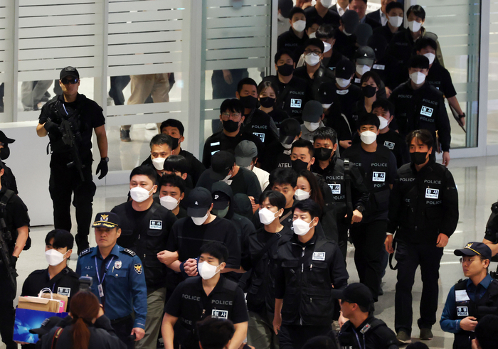 캄보디아 온라인 사기에 가담해 구금된 한국인들이 18일 오전 인천국제공항 제2터미널을 통해 송환되고 있다. 이날 송환에는 경찰 호송조 190여명이 투입됐다. 연합뉴스