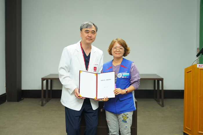양동헌 경북대병원장(왼쪽)과 김영희 공공운수노조 의료연대본부 대구지역지부장이 20일 열린 2025년 임금 및 단체협약 조인식에서 협약서를 들어 보이고 있다.<경북대병원 제공>