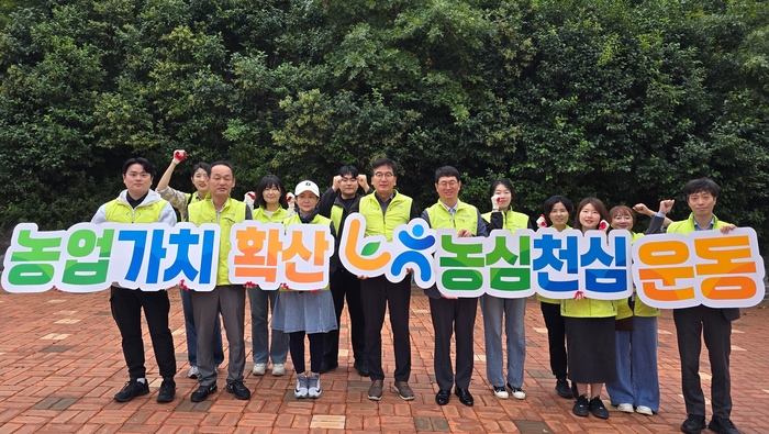 NH농협은행 달성군지부와 달성군청출장소 직원들이 농업가치 확산, 농심천심운동 현수막을 들고 기념촬영을 하고 있다.<달성군지부 제공>