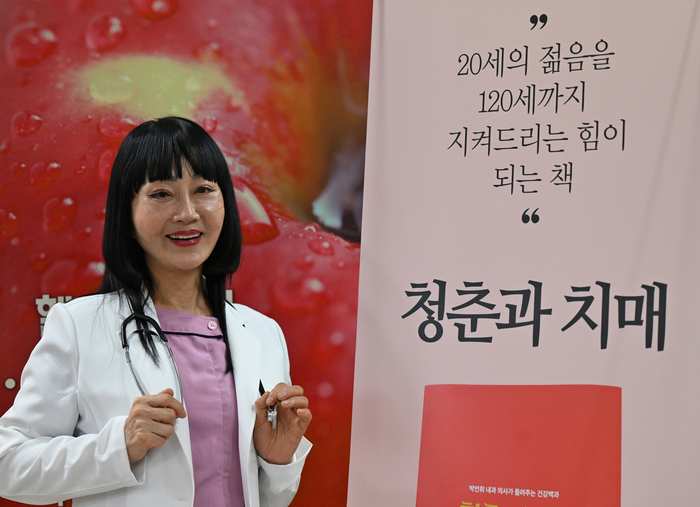 박언휘 종합내과 원장이 자신의 저서 청춘과 치매 앞에서 환하게 미소 짓고 있다. 박 원장은