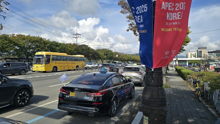 경주시내 도로를 달리는 택시 차량이 APEC 2025 KOREA 문구와 엠블럼이 새겨진 차량용 대회기를 달고 있다. 경주 전역에는 APEC 정상회의를 알리는 현수막과 깃발이 설치돼 도시 전역이 행사 분위기를 띠고 있다. 장성재 기자