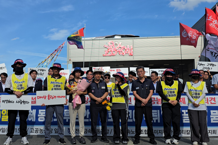 이지영 한국옵티칼하이테크지회 사무장과 남은 해고노동자들이 600일간의 고공농성 후 땅으로 내려온 박정혜 부지회장을 맞이하고 있다. 뒤로 박 부지회장이 고공농성을 한 옥상이 보인다. 박용기기자