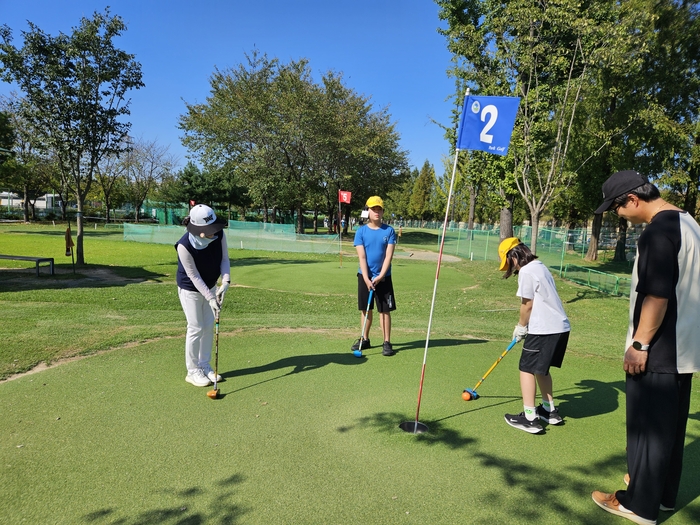 3대가 파크골프를 즐기는 모습.