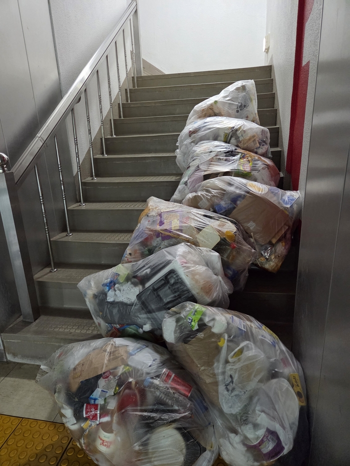한 대학의 기숙사 계단에 쌓여있는 쓰레기. 한 여성 노동자는 
