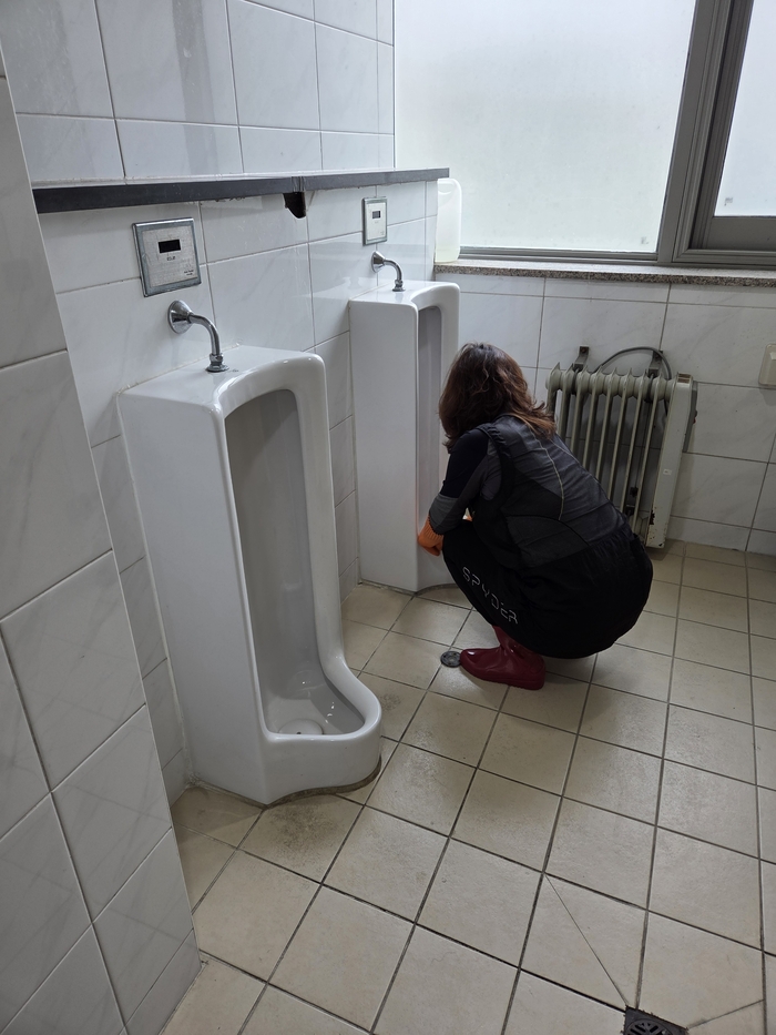 한 여성청소노동자가 바닥에 쭈그리고 않아 남자 소변기를 닦고 있다.<익명을 요구한 여성청소노동자 제공>