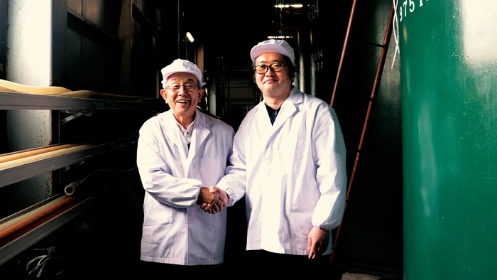 묘코주조 전 도조인 히라타 모리(왼쪽)씨가 후임 도조와 악수를 하며 기념촬영을 하고 있다. <일본M&A센터 제공>