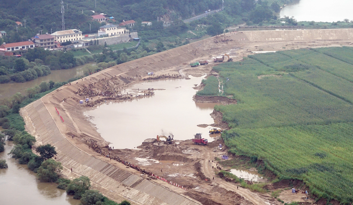 북한의 건설노동자들이 압록강 하류에서 지난해 대홍수로 유실된 제방을  쌓고 있다.