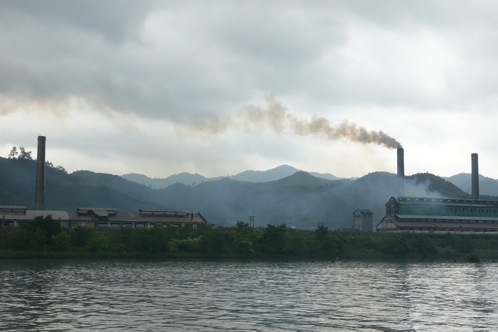 압록강 유람선에서 바라본 북한 땅. 평안북도 청수군 청수노동자지구의 한 공장에서 연기가 피어오르고 있다.