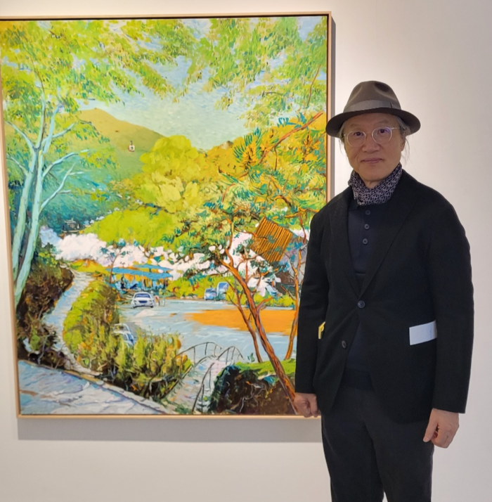 한의사이자 화가인 정성채 작가가 대덕문화전당에서 전시 중인 자신의 신작 앞산케이블카 풍경 앞에서 포즈를 취하고 있다. <임훈기자 hoony@yeongnam.com>