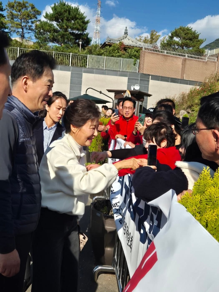 박근혜 전 대통령이 1일 대구 달성군 유가읍 사저 앞에서 국민의힘 달서갑 당원협의회 당원들을 반갑게 맞이하며 악수를 나누고 있다.<유 의원 페이스북 캡처>