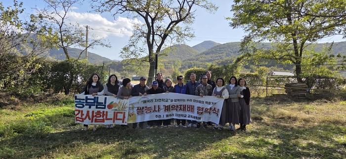 최근 대구시 군위군 효령면 매곡1리에서 시골 어르신과 도시 어린이집 원장이 모여 쌀농사 계약재배 협약식을 진행한 후 기념촬영을 하고 있다. 앞줄 여섯째가 매곡리 자연학교를 운영하는 원필선 목사.