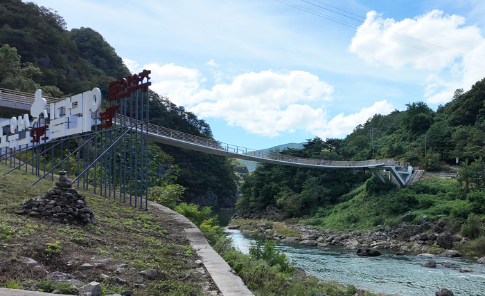 낙동강 절벽 사이를 잇는 봉화 선유교의 전경. 푸른 하늘과 산세가 어우러지며, 다리 아래로 낙동강의 물줄기가 유유히 흐르고 있다. <봉화군 제공>