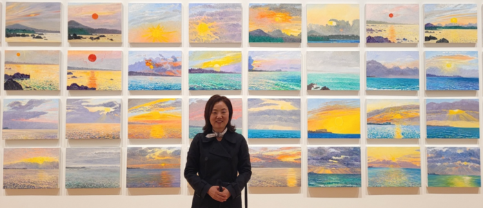 허윤희 작가가 제주의 해돋이를 담아낸 해돋이 일기 시리즈 앞에서 포즈를 취하고 있다. <임훈기자 hoony@yeongnam.com>