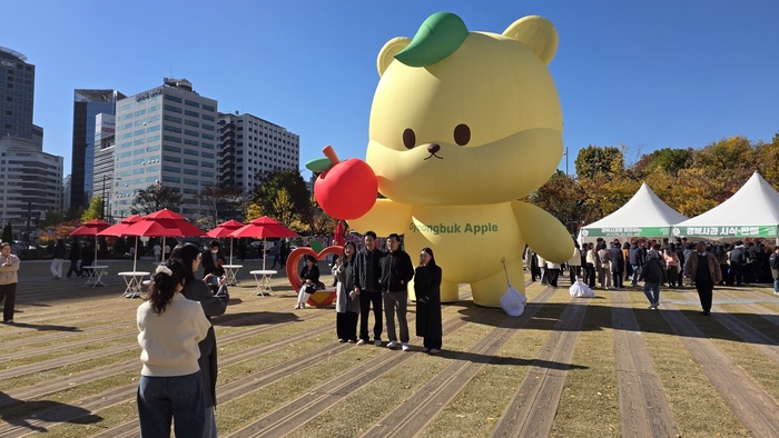 서울시청 광장에서 펼쳐진 경북사과홍보행사에서 경북사과를 들고 있는 대형 곰돌이가 시민들에게 인기를 끌고 있다.<정운홍기자>