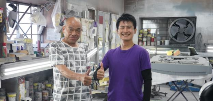 고바야시 마사토시(왼쪽) 고바야시 오토 대표와 사노 토모카즈가 기업 인수합병을 결정한 뒤 작업장을 배경으로 기념촬영을 하고 있다. <고바야시씨 제공>