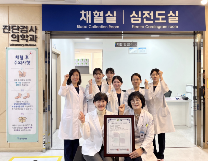 드림종합병원 진단검사의학과 의료진이 우수검사실 신임 인증 획득을 기념해 채혈실 앞에서 인증서를 들고 기념촬영을 하고 있다.<드림종합병원 제공>
