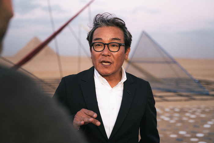 박종규 작가가 이집트 피라미드 앞에 설치된 자신의 작품에 대해 설명하고 있다.<Studio J.Park / 이앤아트 제공>