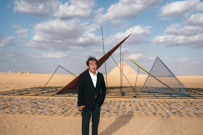박종규 작가가 이집트 기자의 피라미드 앞에서 전시 중인 자신의 작품  영원의 코드(Code of the Eternal) 앞에서 포즈를 취하고 있다. <Studio J.Park / 이앤아트 제공>