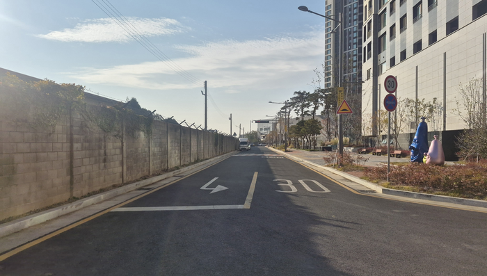 3차 순환도로 마지막 미개통 구간인 서편 600m 중, 힐스테이트 1차 주택사업자가 조성해 시에 기부채납한 직선 도로 구간. 왼편으로 캠프워커 담장이 보인다. 남구청은 미군 부지를 반환받으면 기존 왕복 2차로를 4차로로 확장할 계획이다. 조윤화 기자