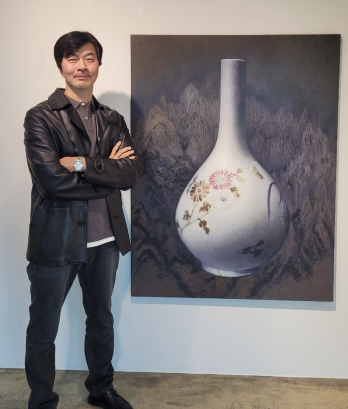 김상우 작가가 백자 청화철채동채초충문 병 뒤로 겸재 정선의 금강전도를 배치한 자신의 작품 앞에서 포즈를 취하고 있다.<임훈기자 hoony@yeongnam.com>