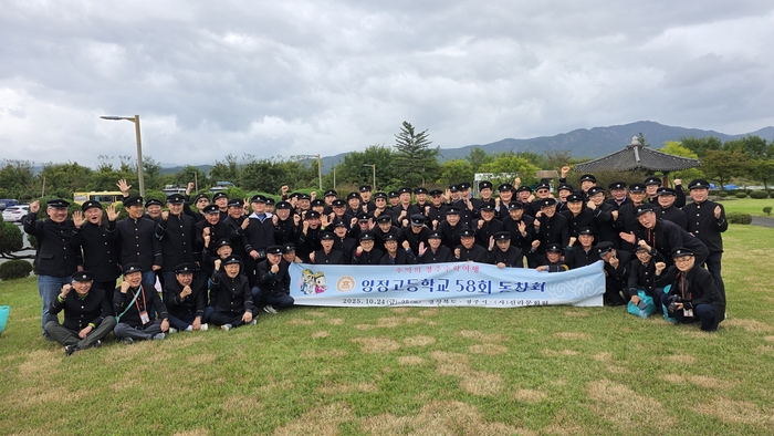 추억의 경주 수학여행 프로그램에 참여한 양정고 58회 동창회 참가자들이 교복을 입고 단체 현수막 앞에서 기념촬영하고 있다. 신라문화원 제공