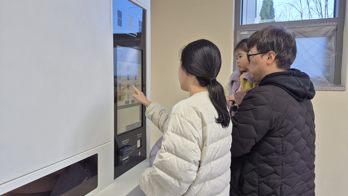 30일 오전 대구 남구 앞산 숲속 책 쉼터 무인카페에서 천진성(39·달서구)씨 가족이 음료를 고르고 있다. 구청은 개장 이벤트로 이용 1시간당 음료 2잔 쿠폰도 제공한다. 조윤화 기자