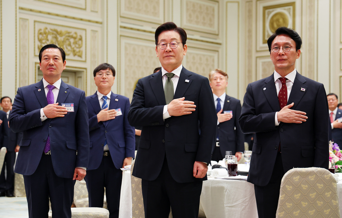 이재명 대통령이 12일 청와대 영빈관에서 열린 시장·군수·구청장 초청 국정설명회에서 국기에 경례하고 있다.  연합뉴스